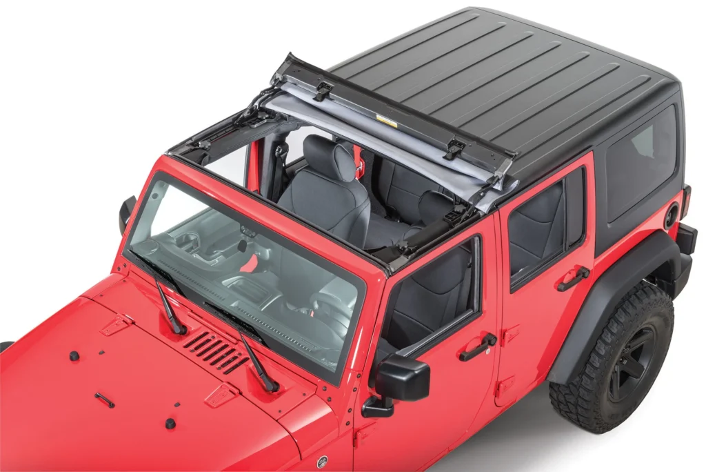 A red four-door Jeep Wrangler with a hardtop and roof rack, shown against a plain white background.