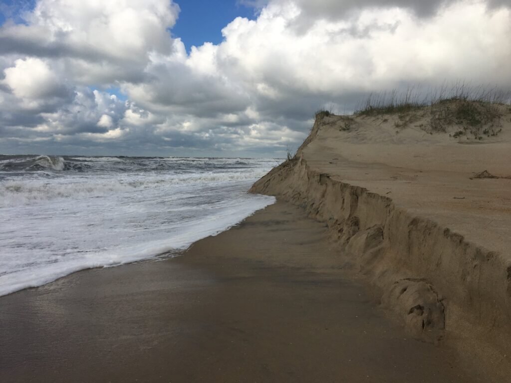 A steep sand scarp cut by waves along the south-facing beach at Cape Point, the kind of drop that stops a two-wheel-drive car.