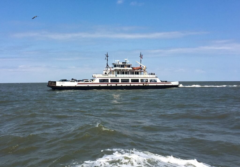 A state ferry underway on flat water between Hatteras Island and Ocracoke Island on a clear day.